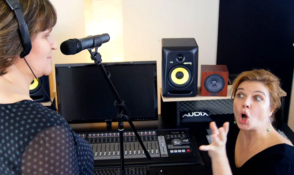 Sängerin im Tonstudio mit Mikrofon, Mischpult und Lautsprechern