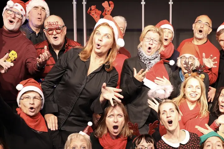 Singende Gruppe mit Weihnachtsmützen und Rentiergeweihen